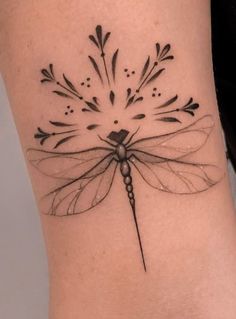 a black and white photo of a dragonfly tattoo