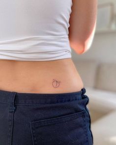 a woman with a small apple tattoo on her stomach