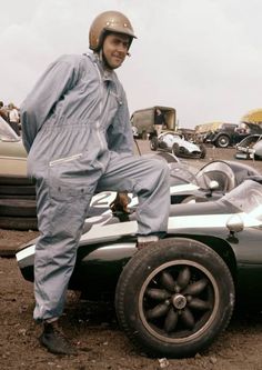 a man standing on the hood of a race car