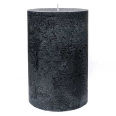 a black candle is sitting on a white surface