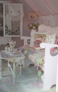 a dollhouse bedroom with pink walls and furniture, including a white bench and table