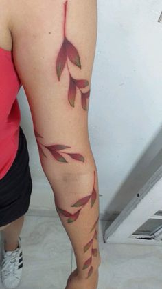 a woman's leg with red leaves on it and the bottom part of her arm