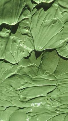 a close up view of green paint on a leafy surface, with the top layer visible