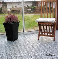 a wooden chair sitting in front of a window next to a potted purple plant