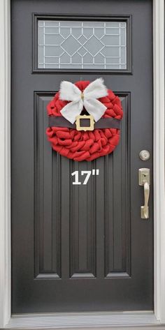 a red and white wreath on the front door