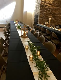 the long table is set with candles and greenery