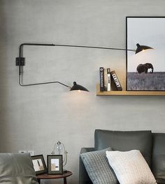 a living room with a gray couch and two framed pictures on the wall above it