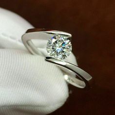 a diamond ring sitting on top of a white cloth