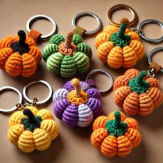 several knitted pumpkin keychains are arranged on a table with metal rings in the shape of small pumpkins