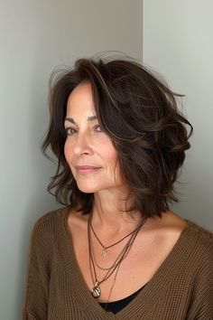 a woman wearing a brown sweater and necklace