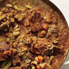 a pot filled with meat and beans on top of a table