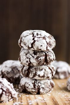 chocolate crinkle cookies stacked on top of each other with powdered sugar on them