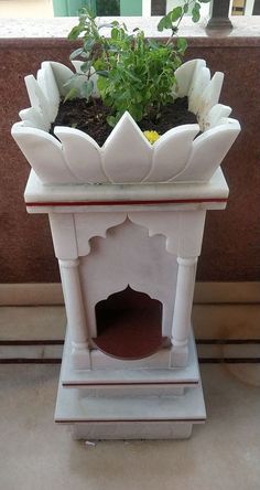 a small white planter with flowers in it