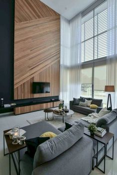 a living room with couches, tables and a flat screen tv on the wall