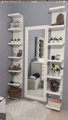 a mirror sitting on top of a white shelf next to a wall filled with shelves