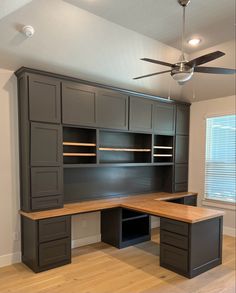 an empty room with cabinets and a ceiling fan