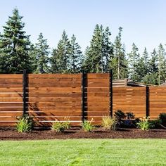 a wooden fence in front of some trees