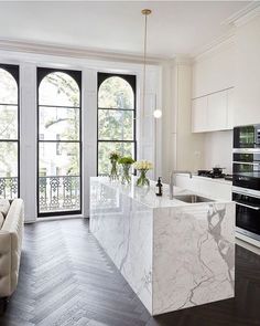 a large kitchen with marble counter tops and an island