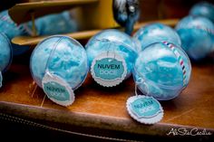 some blue balls with tags on them are sitting on a wooden table next to other ornaments