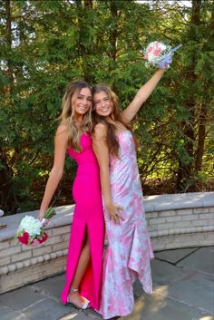 two beautiful young women standing next to each other holding bouquets in their hands and posing for the camera