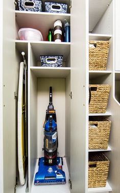 the closet is filled with various items and storage bins, including a vacuum cleaner