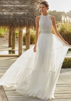 a woman in a white dress standing on a dock