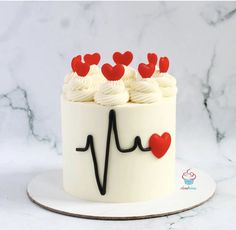 a cake with white frosting and red hearts on the top is decorated like a heartbeat