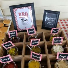 an assortment of pickles and other condiments are displayed in wooden boxes on a table