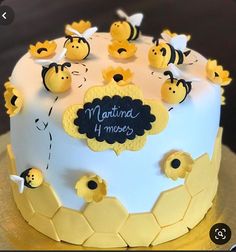 a cake decorated with bees and honeycombs for a baby's first birthday