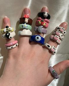 a person's hand with many different rings on it, all decorated in cartoon characters