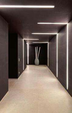 an empty hallway with white lights and vases on either side in front of it