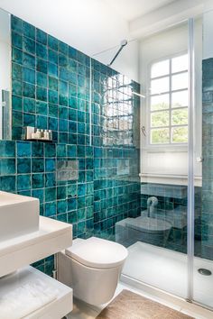 a bathroom with blue tiles on the walls