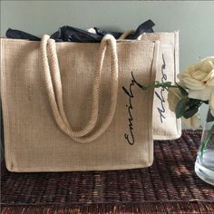 a jute bag sitting on top of a table next to a vase with flowers