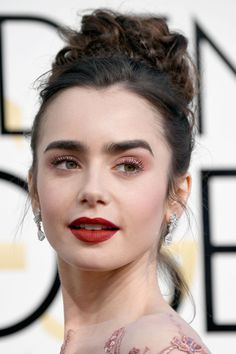 an image of a woman with red lipstick on her face and hair in a bun