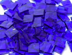 a pile of purple glass tiles sitting on top of a table