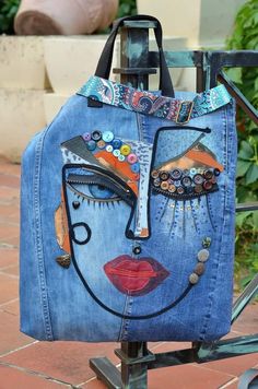 a handbag made out of jeans with an image of a woman's face on it