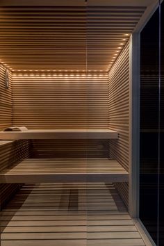 an empty sauna with wooden slatted walls and lights on the ceiling is shown