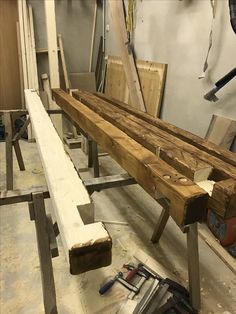 a wooden bench sitting inside of a room next to other pieces of wood and tools