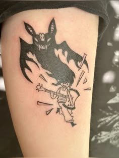 a tattoo on the leg of a person with a bat and demon design in black ink