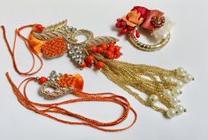 Set of 2 Rakhi / Bhaiya-Bhabhi Rakhi With Beautiful Roli and Chaval Favor - My Aashis Orange Jewelry For Diwali Puja, Multicolor Sets For Navratri Gift, Festive Orange Jewelry For Gift, Festive Orange Jewelry Gift, Red Sets For Festivals And Gifts, Red Festival Sets For Gift, Red Festival Sets As Gifts, Bollywood Style Red Sets Perfect As Gift, Bollywood Style Red Sets As Gift