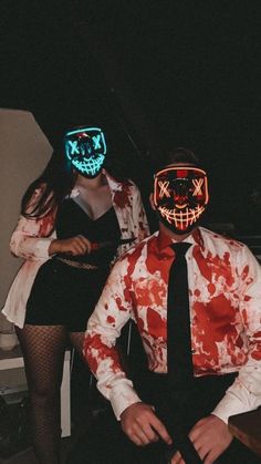 two people in costumes with neon masks on their faces and one person wearing a tie