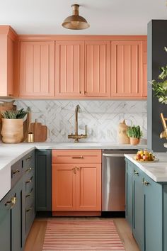 an orange and blue kitchen with wooden cabinets, marble backsplash, gold accents