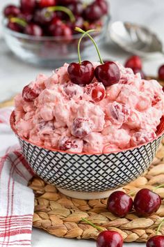 a bowl filled with cherries on top of a table