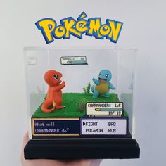 someone is holding up a pokemon figurine display case