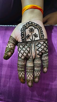 a woman's hand with henna on it and flowers painted on the palm