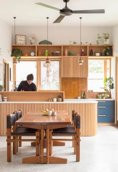 a person sitting at a table in a kitchen