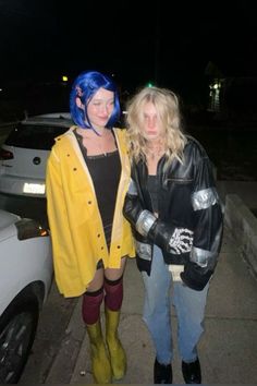 two women standing next to each other on a sidewalk