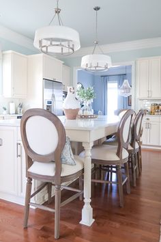 a dining room table with chairs around it in front of an oven and refrigerator freezer