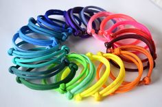 a bunch of different colored cords on a white surface with one knot in the middle