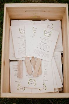 an open wooden box filled with lots of cards and papers on top of green grass